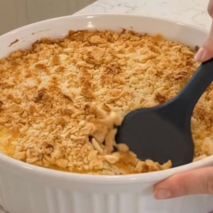 A golden, bubbling chicken casserole in a fluted white dish, fresh from the oven with a crispy cracker topping.