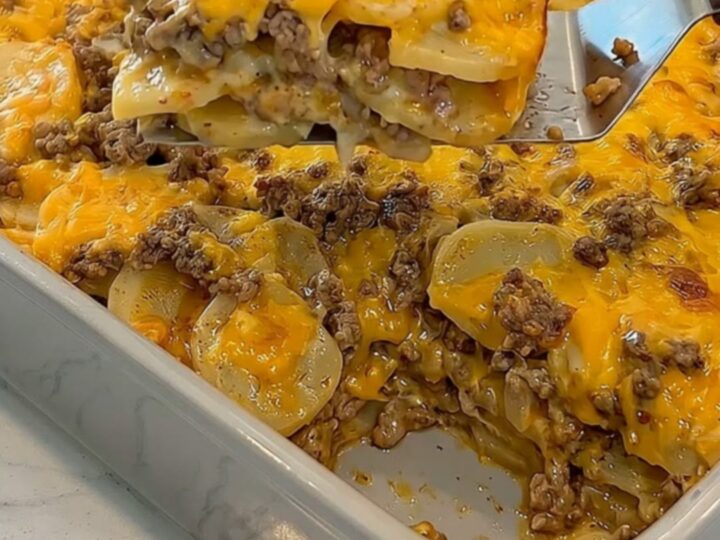 A golden, bubbling cheesy hamburger potato casserole in a grey ceramic dish.