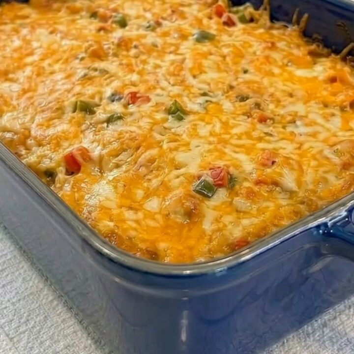 A steamy square of King Ranch chicken casserole being lifted from a blue dish.