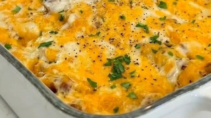 A bubbly, golden-brown Hobo Casserole in a white baking dish with visible layers of beef and potatoes.
