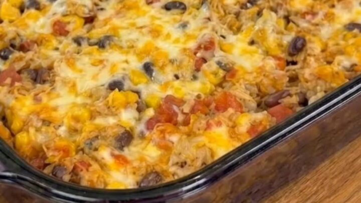 A warm, cheesy Mexican chicken casserole in a glass dish with a spatula scooping out a portion.
