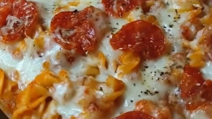 A steaming hot pizza pasta casserole in a glass baking dish with melted mozzarella and pepperoni.