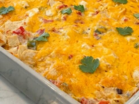 A golden, bubbling King Ranch Chicken Casserole in a grey ceramic dish, garnished with fresh cilantro.