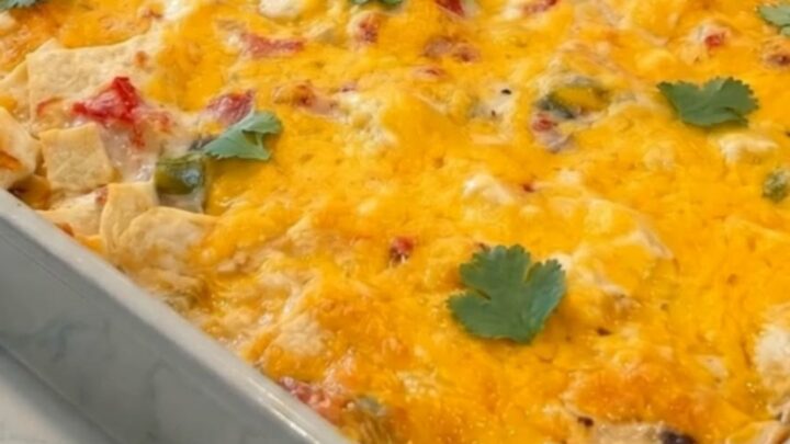 A golden, bubbling King Ranch Chicken Casserole in a grey ceramic dish, garnished with fresh cilantro.