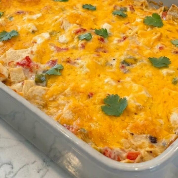 A golden, bubbling King Ranch Chicken Casserole in a grey ceramic dish, garnished with fresh cilantro.