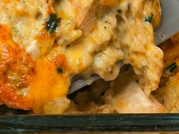 A golden-brown, cheesy chicken and broccoli rice casserole in a glass baking dish, steaming hot and ready to serve.