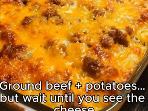 A golden-brown, bubbly cheesy hamburger and potato casserole in a 9x13 glass dish.