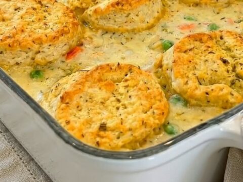 A warm, golden-brown chicken pot pie casserole in a white baking dish.