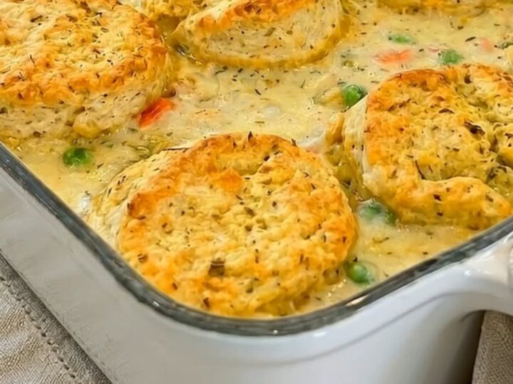 A warm, golden-brown chicken pot pie casserole in a white baking dish.