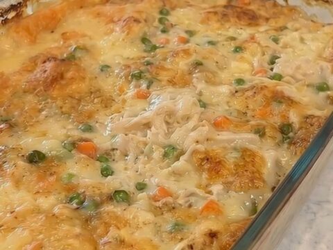 A bubbly, golden-baked creamy chicken and dumpling casserole in a glass baking dish.