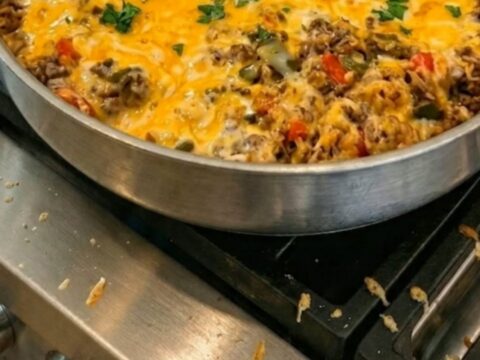 A stainless steel skillet filled with a hearty mixture of ground beef, rice