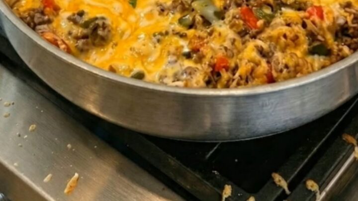 A stainless steel skillet filled with a hearty mixture of ground beef, rice