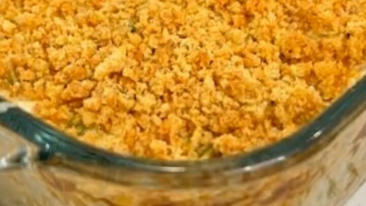 A warm, creamy chicken casserole in a glass dish with a golden, buttery cracker crust and fresh parsley.