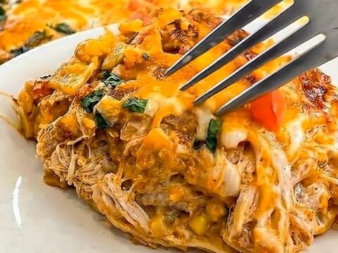 A golden, bubbly King Ranch Chicken Casserole in a baking dish with a visible cheese pull.