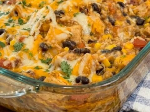 A golden-brown cheesy Mexican chicken casserole in a glass baking dish, fresh from the oven.