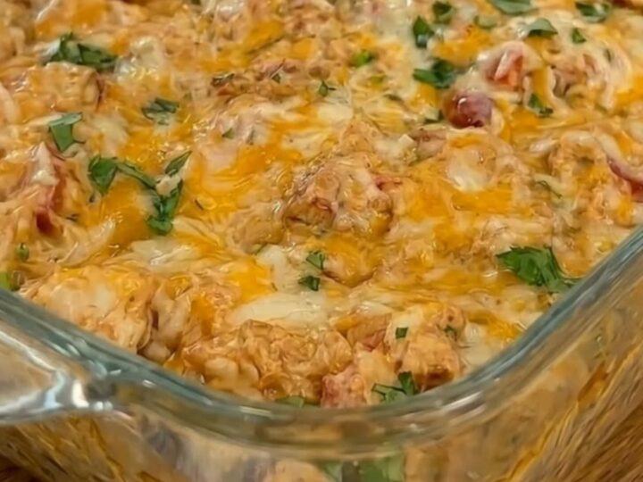 A golden, bubbling queso chicken and rice casserole in a glass baking dish, fresh from the oven.