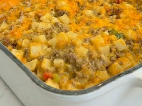 A golden, bubbly cheesy ground beef and potato casserole in a white baking dish.