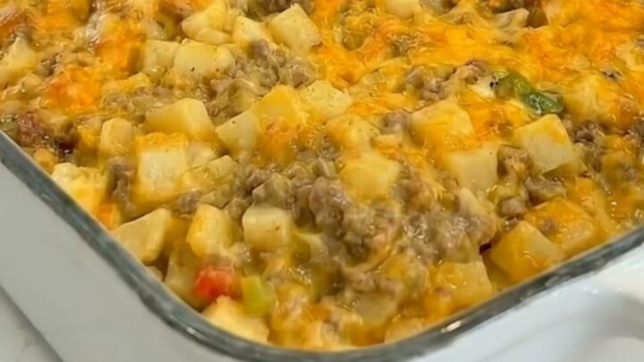 A golden, bubbly cheesy ground beef and potato casserole in a white baking dish.