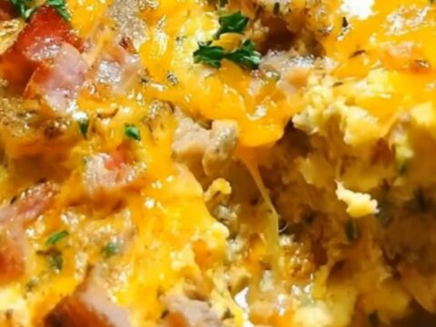 A steaming breakfast casserole in a slow cooker topped with melted cheese and fresh parsley.