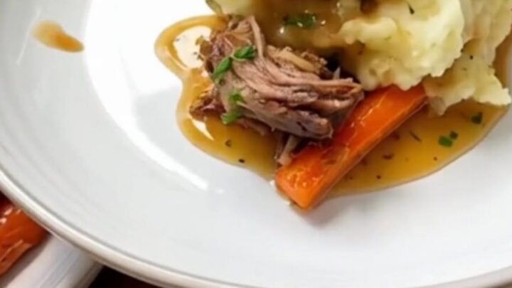 A close-up of a hearty portion of herb butter chicken with roasted carrots and creamy mashed potatoes.