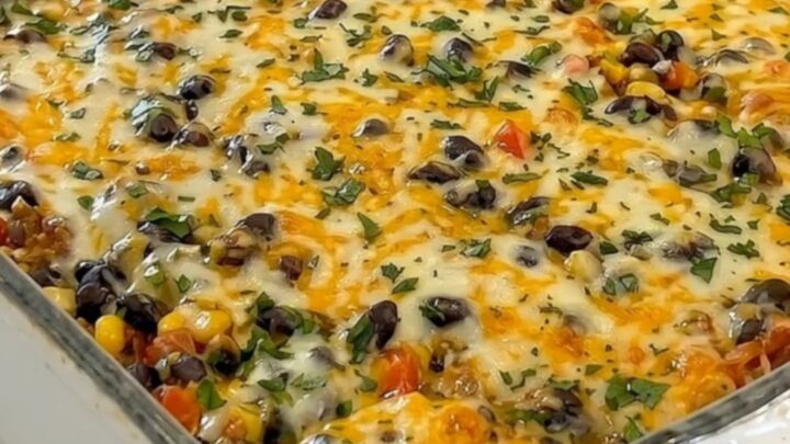 A golden, bubbling tray of cheesy taco lasagna in a white rectangular dish.