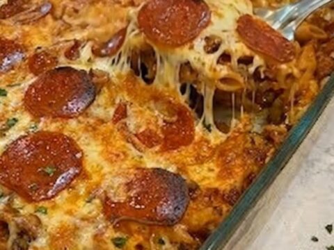 A warm casserole dish filled with baked penne pasta, topped with melted mozzarella and crispy pepperoni slices.