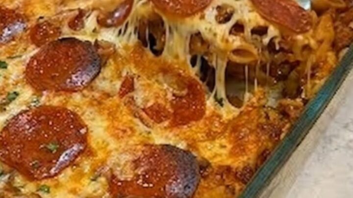 A warm casserole dish filled with baked penne pasta, topped with melted mozzarella and crispy pepperoni slices.