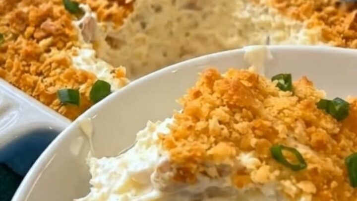A golden, bubbly Million Dollar Chicken Casserole in a white ceramic dish with a crispy cracker topping.