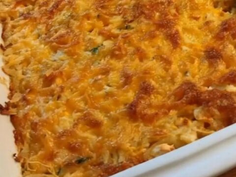 A steaming, golden-brown chicken and hash brown casserole in a rectangular baking dish.