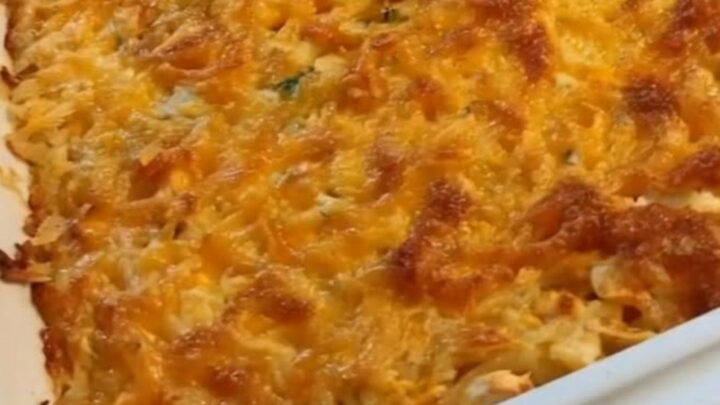 A steaming, golden-brown chicken and hash brown casserole in a rectangular baking dish.