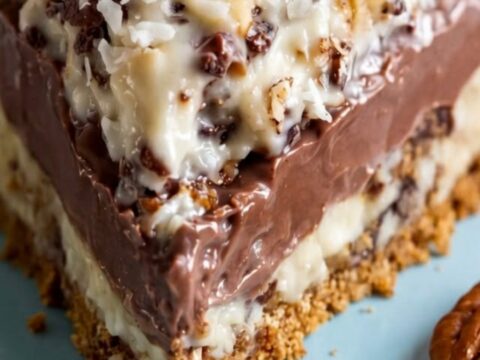 A slice of sugar-free German chocolate pie on a white plate with visible chocolate filling and toasted coconut.