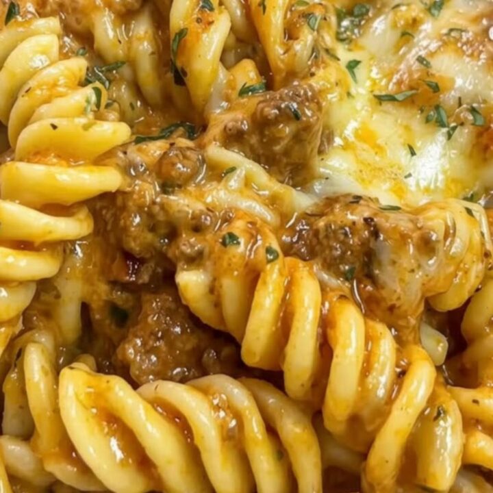 A close-up of creamy rotini pasta with ground beef and melted cheese in a large skillet.