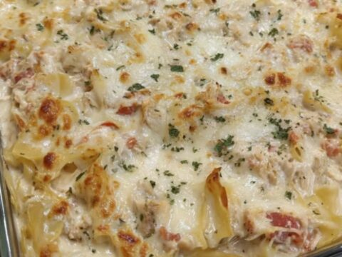 A golden, bubbling chicken spaghetti bake in a glass dish with melted mozzarella.