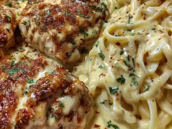 A white bowl filled with creamy Cajun alfredo linguine alongside sliced, golden-brown seared chicken.