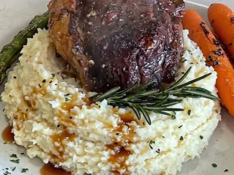 A perfectly seared filet mignon served over fluffy mashed cauliflower with roasted carrots and asparagus.