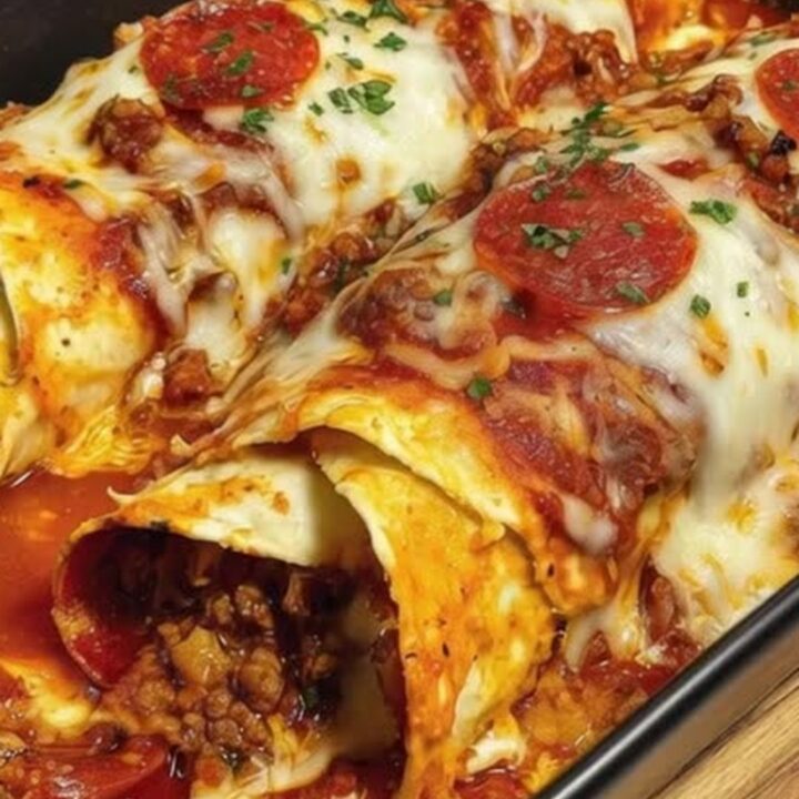 A spatula lifting a cheesy slice of ground beef pizza enchiladas with a dramatic mozzarella cheese pull.