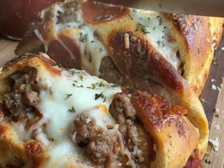 A golden, baked pizza bread loaf showing signs of a crispy, pepperoni-topped crust.