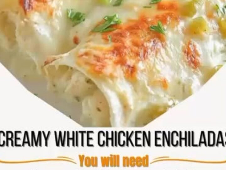 A close-up of creamy white chicken enchiladas in a baking dish with a cheese pull.