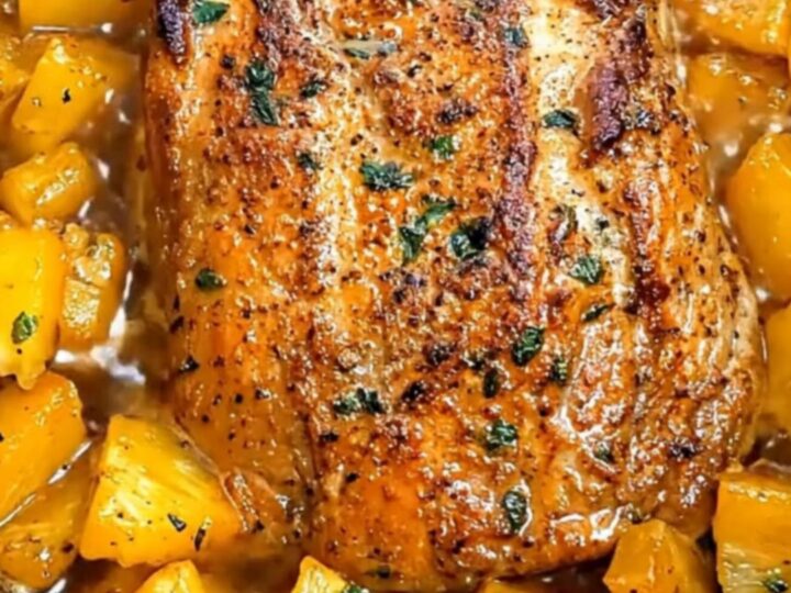 Slices of tender, succulent glazed pork loin surrounded by bubbling pineapple chunks in a slow cooker.