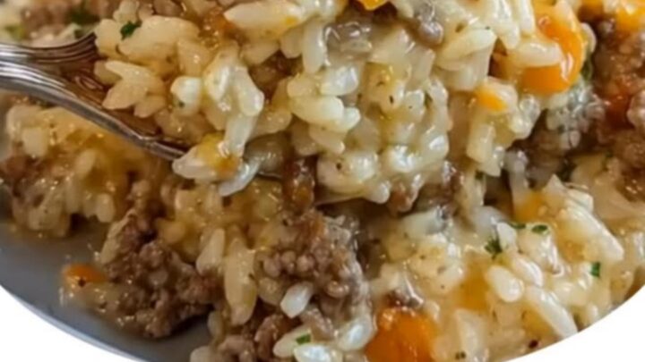A golden, bubbly cheesy ground beef and rice casserole in a baking dish, freshly pulled from the oven.