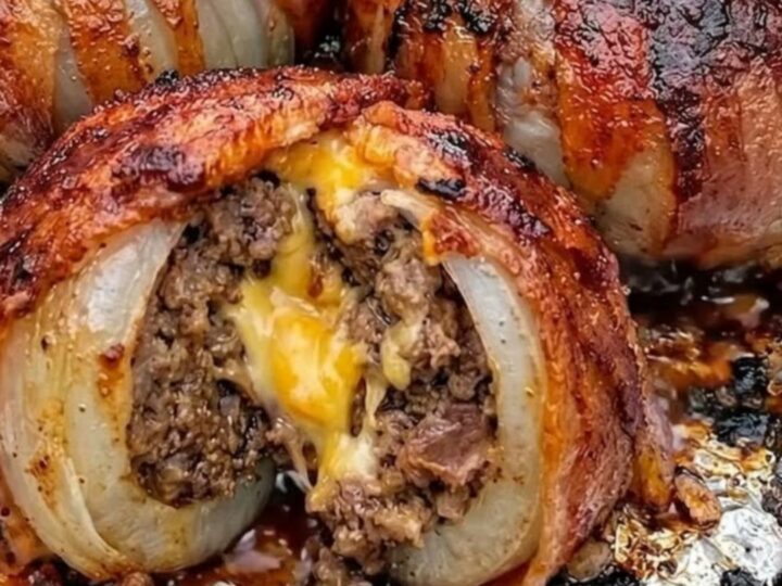 Golden, bacon-wrapped onion bombs fresh from the oven on a baking sheet.