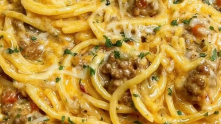A steaming, rich portion of creamy Cajun beef spaghetti served in a ceramic bowl.