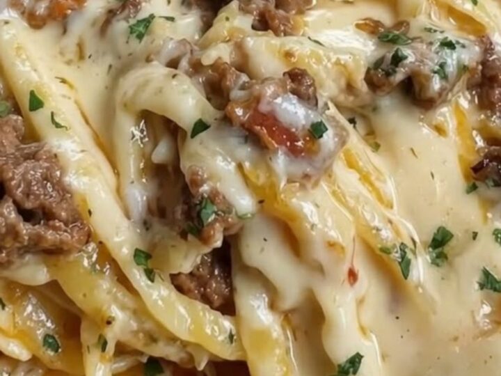 A steaming plate of creamy garlic butter beef linguine with visible cheese pulls.
