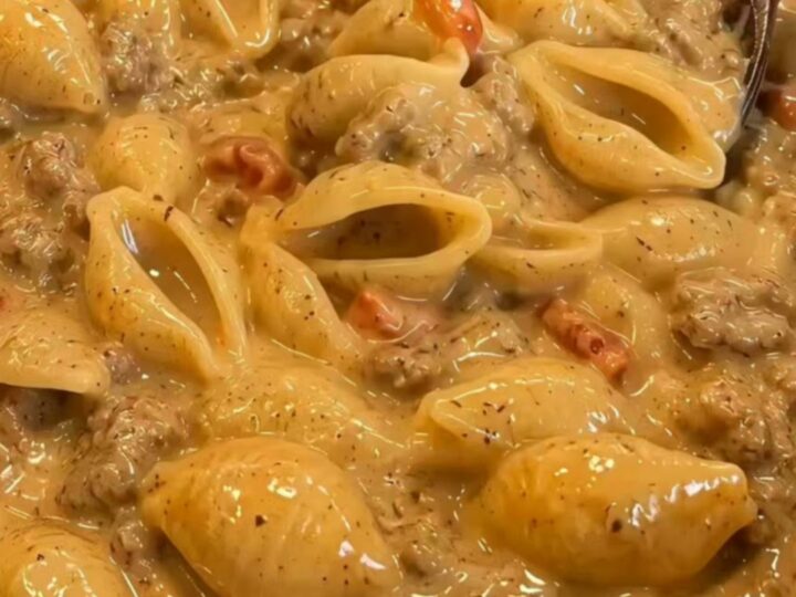 A steaming bowl of creamy taco pasta with large shells and a rich meat sauce.