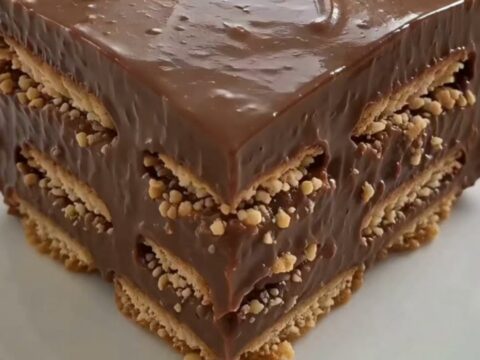 A tall, square slice of chocolate icebox cake on a white plate with visible layers.