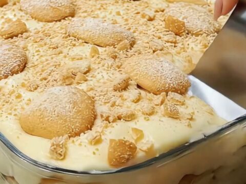 A glass casserole dish filled with layers of creamy vanilla pudding, sliced bananas, and vanilla wafers.