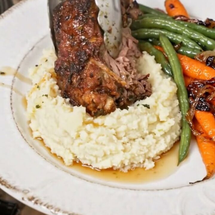 A perfectly roasted prime rib with a golden garlic herb crust served on a white platter.