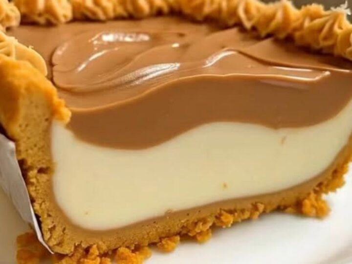 A thick, creamy slice of peanut butter pie on a white plate with a crisp graham cracker crust.
