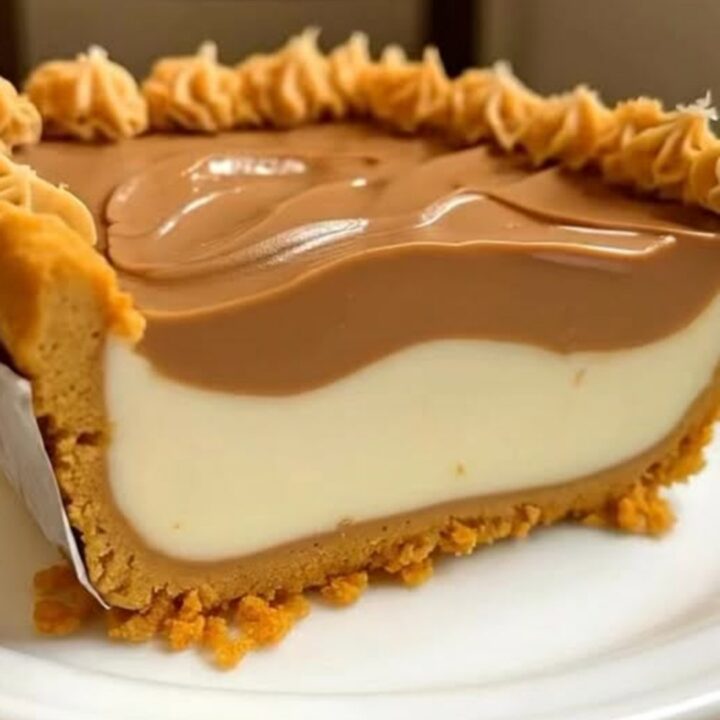 A thick, creamy slice of peanut butter pie on a white plate with a crisp graham cracker crust.