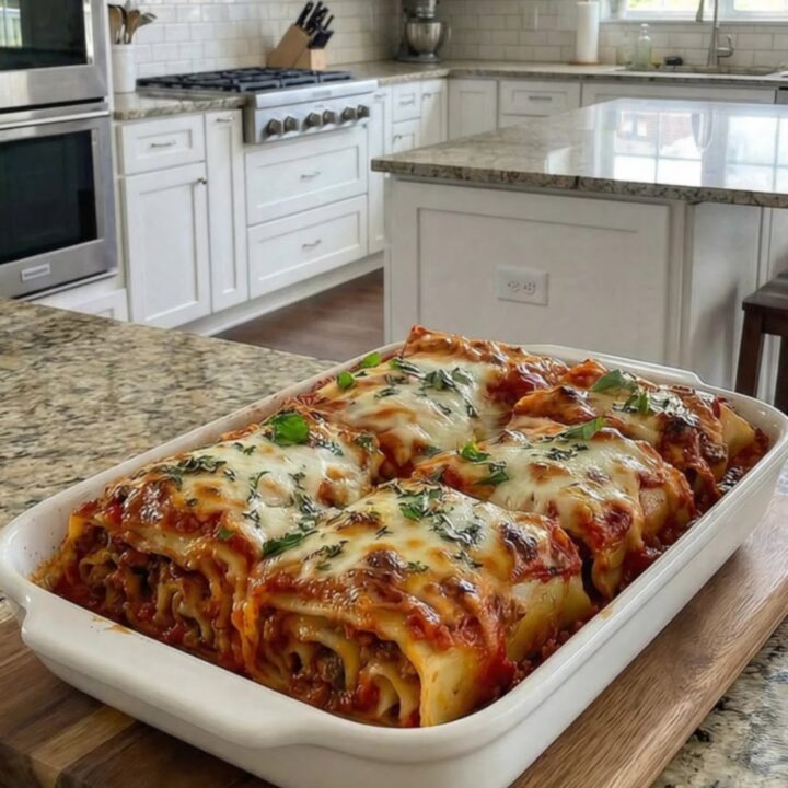 A steaming, freshly baked beef lasagna in a white dish with a rich meat sauce and melted cheese.